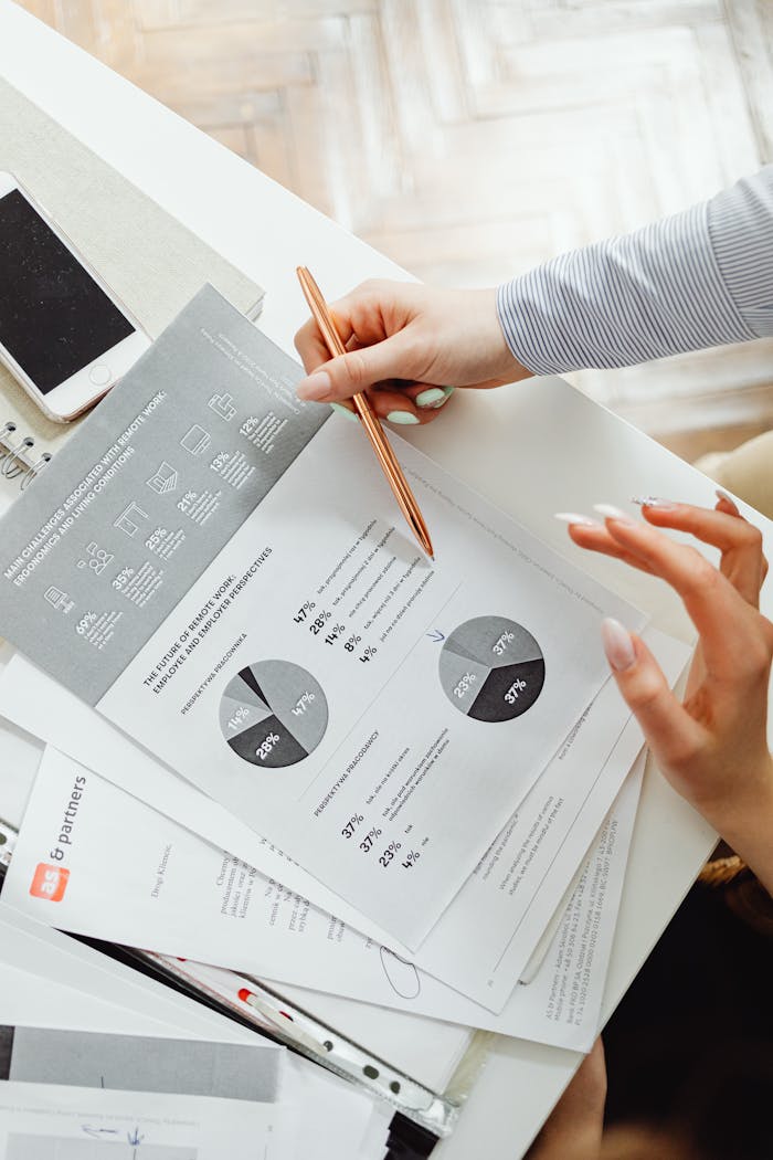 Close-up of businesswoman analyzing financial reports using pie charts in an office setting.